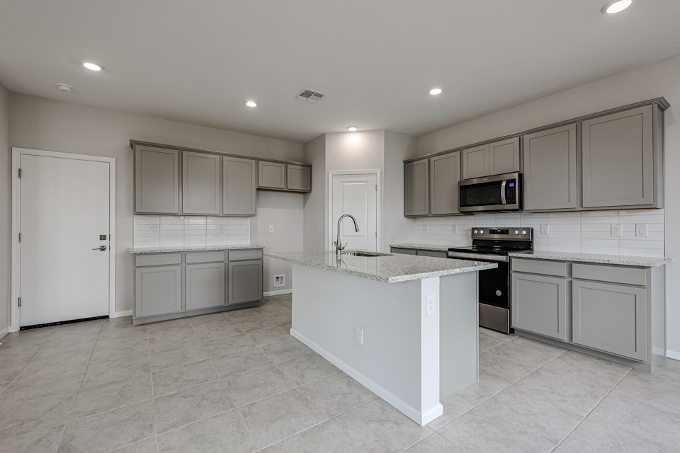 A kitchen with white cabinets.