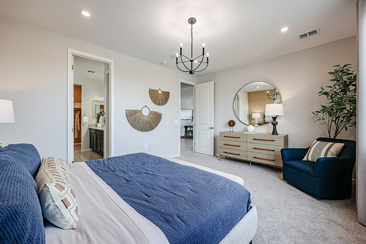 A bedroom with a bed and a chair.