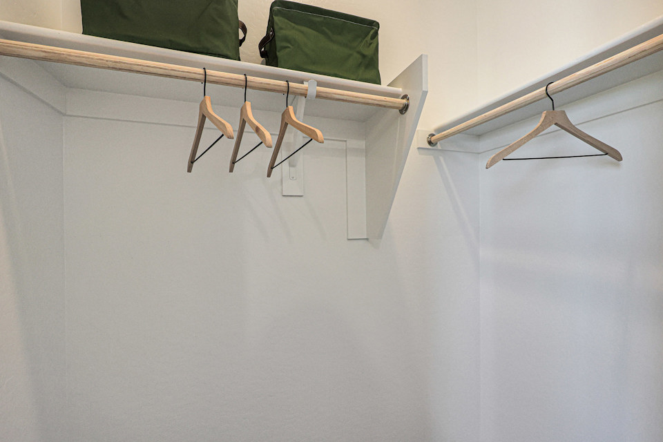 A white wall with a green pillow and a green pillow.