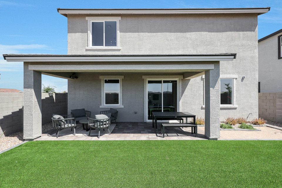 A house with a lawn and chairs.