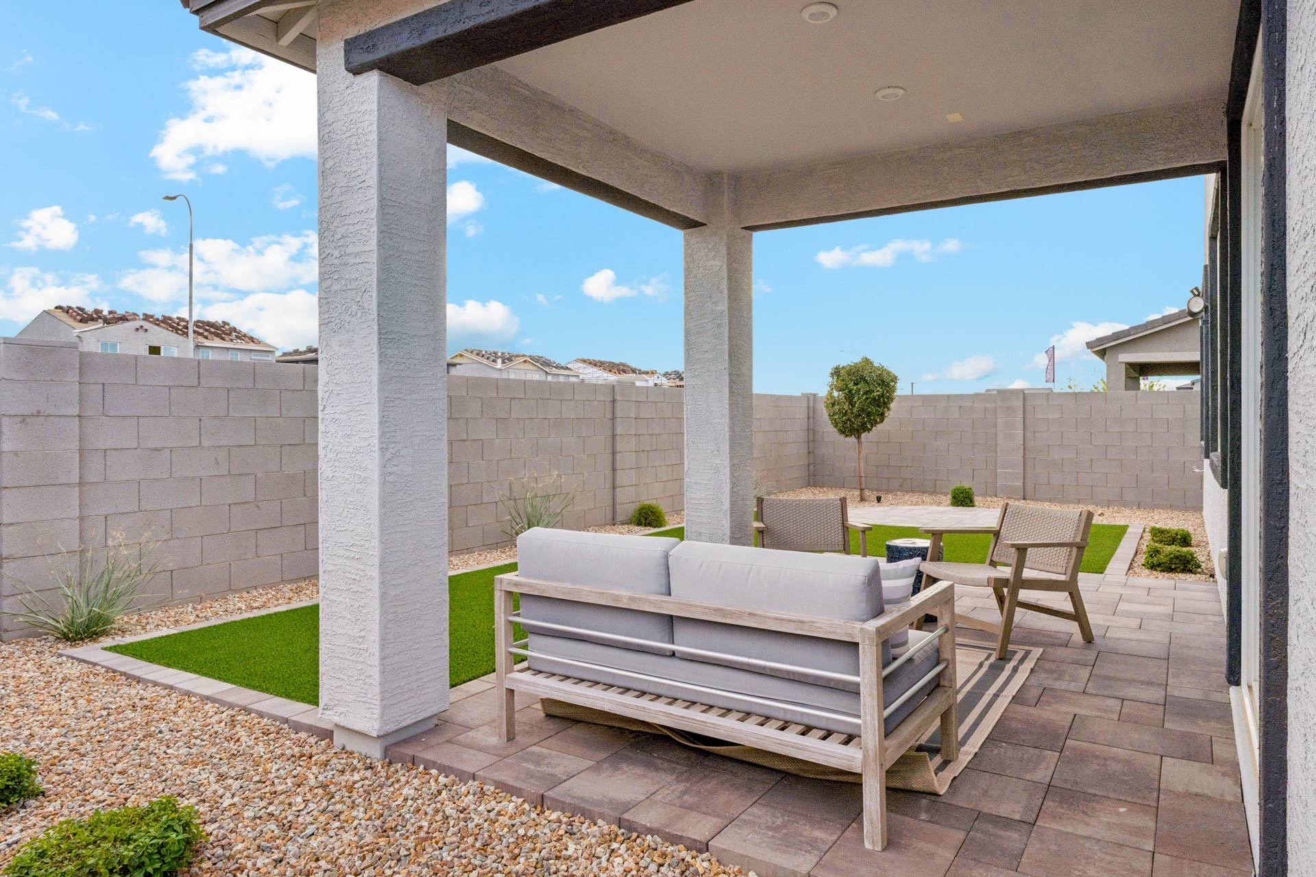 A patio with a bench and a table and chairs.