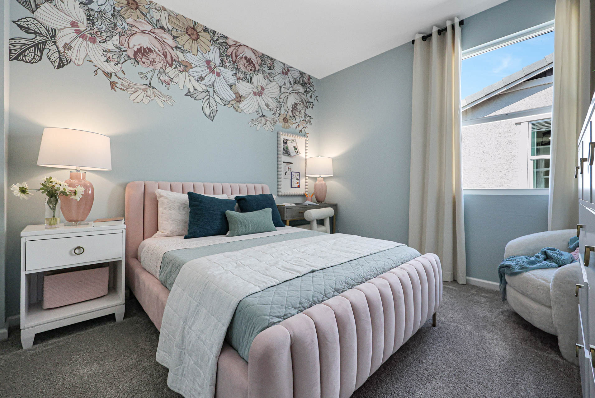 A bedroom with a bed and lamps.