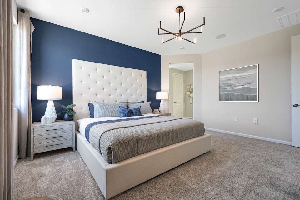 A bedroom with a bed and lamps.