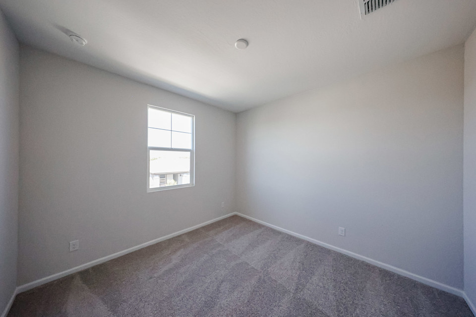 A room with a carpet and a window.