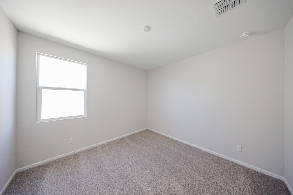 A room with a carpet and windows.