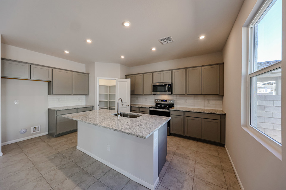 A kitchen with a marble counter top.