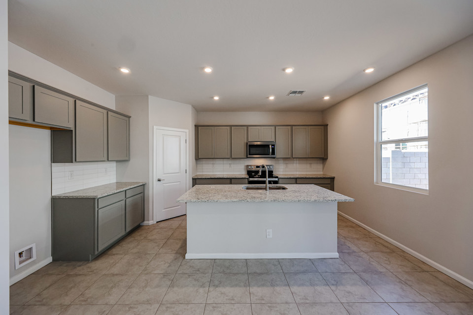 A kitchen with a marble counter top.