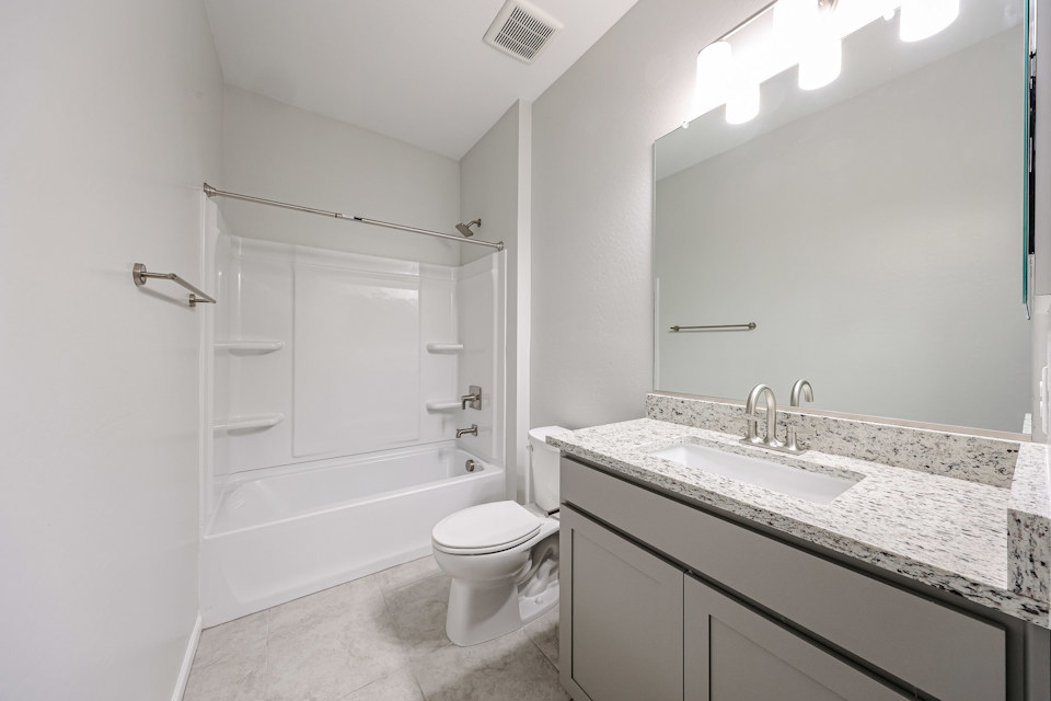 A bathroom with a tub sink and toilet.
