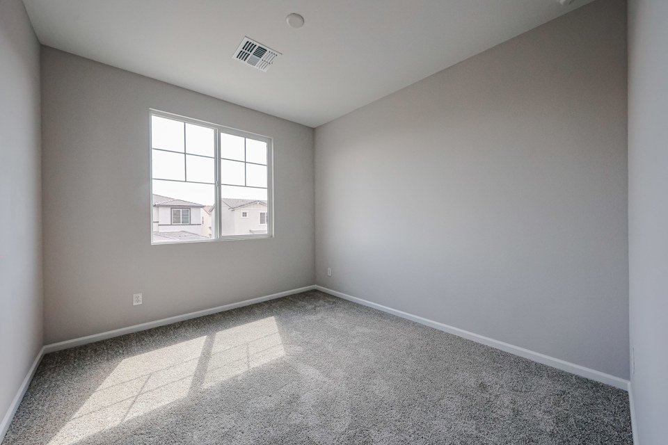 A room with a window and a carpet.