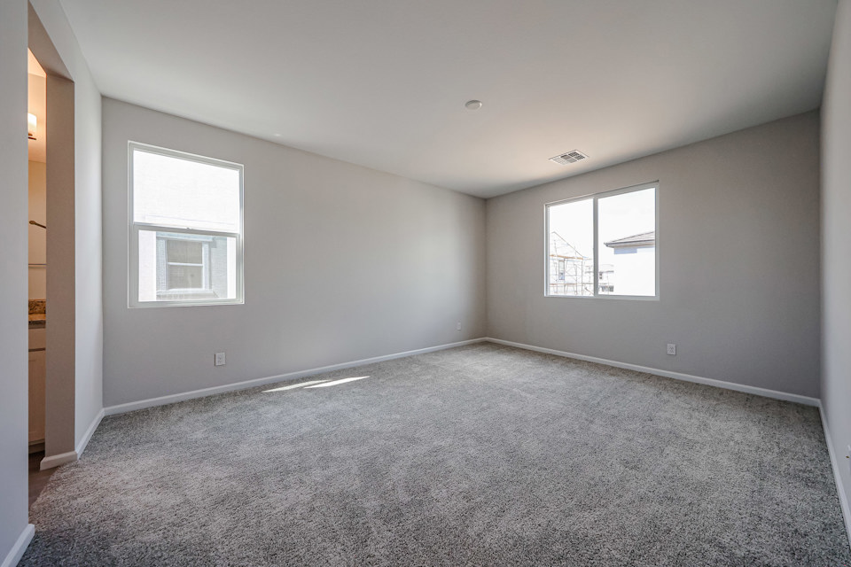 A room with a carpet and windows.