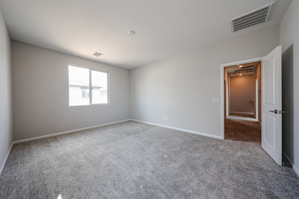 A room with a carpet and a door.