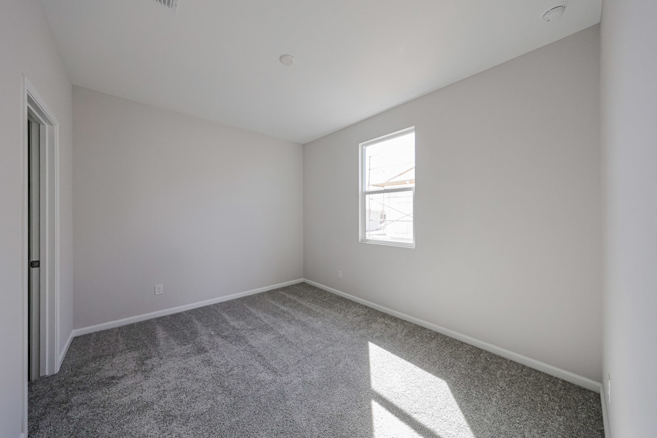 A room with a window and a carpet.