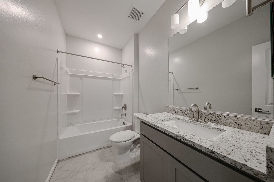 A bathroom with a tub sink and toilet.