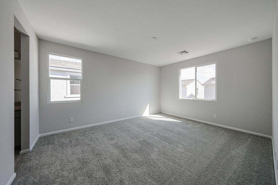 A room with a carpet and windows.