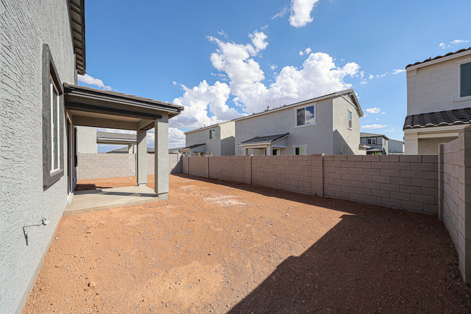 A dirt road between buildings.