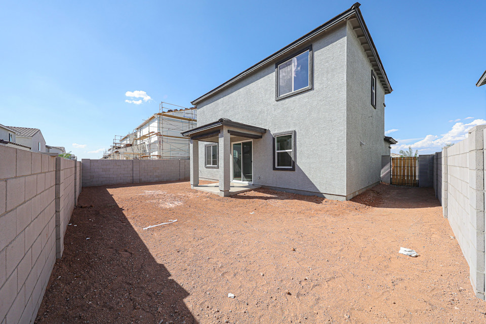 A dirt road with a building on the side.