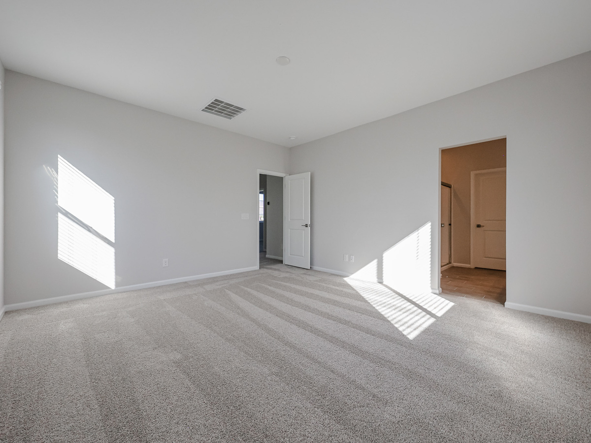 A room with a carpet and a door.