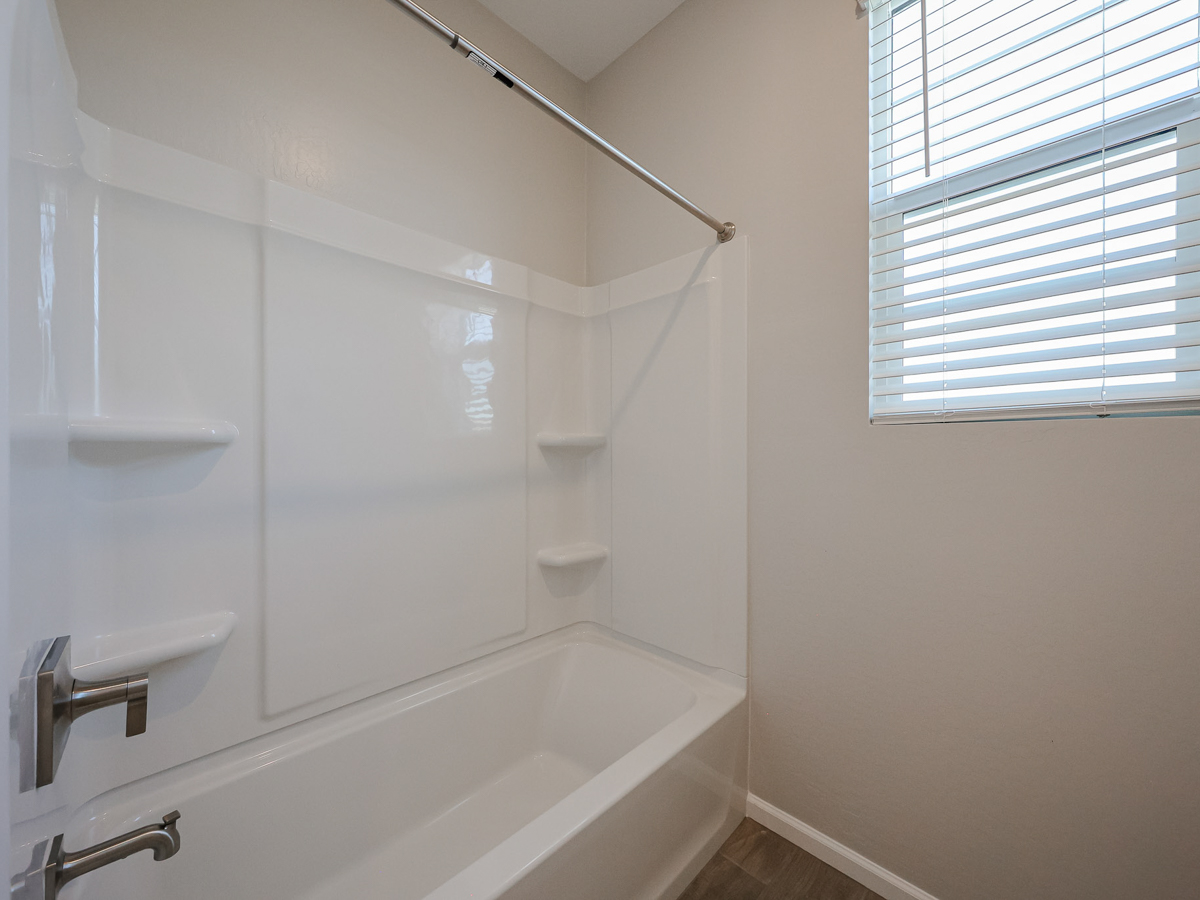 A bathroom with a bathtub and shower.