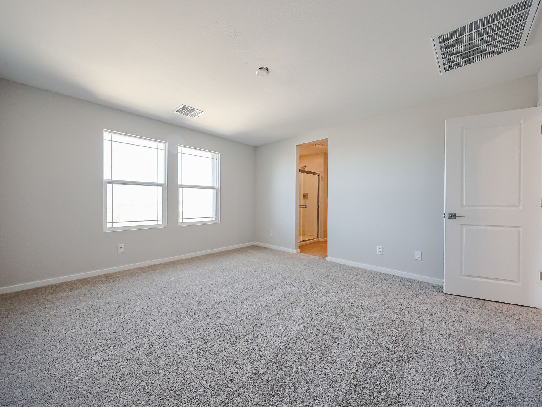 A room with a carpet and a door.