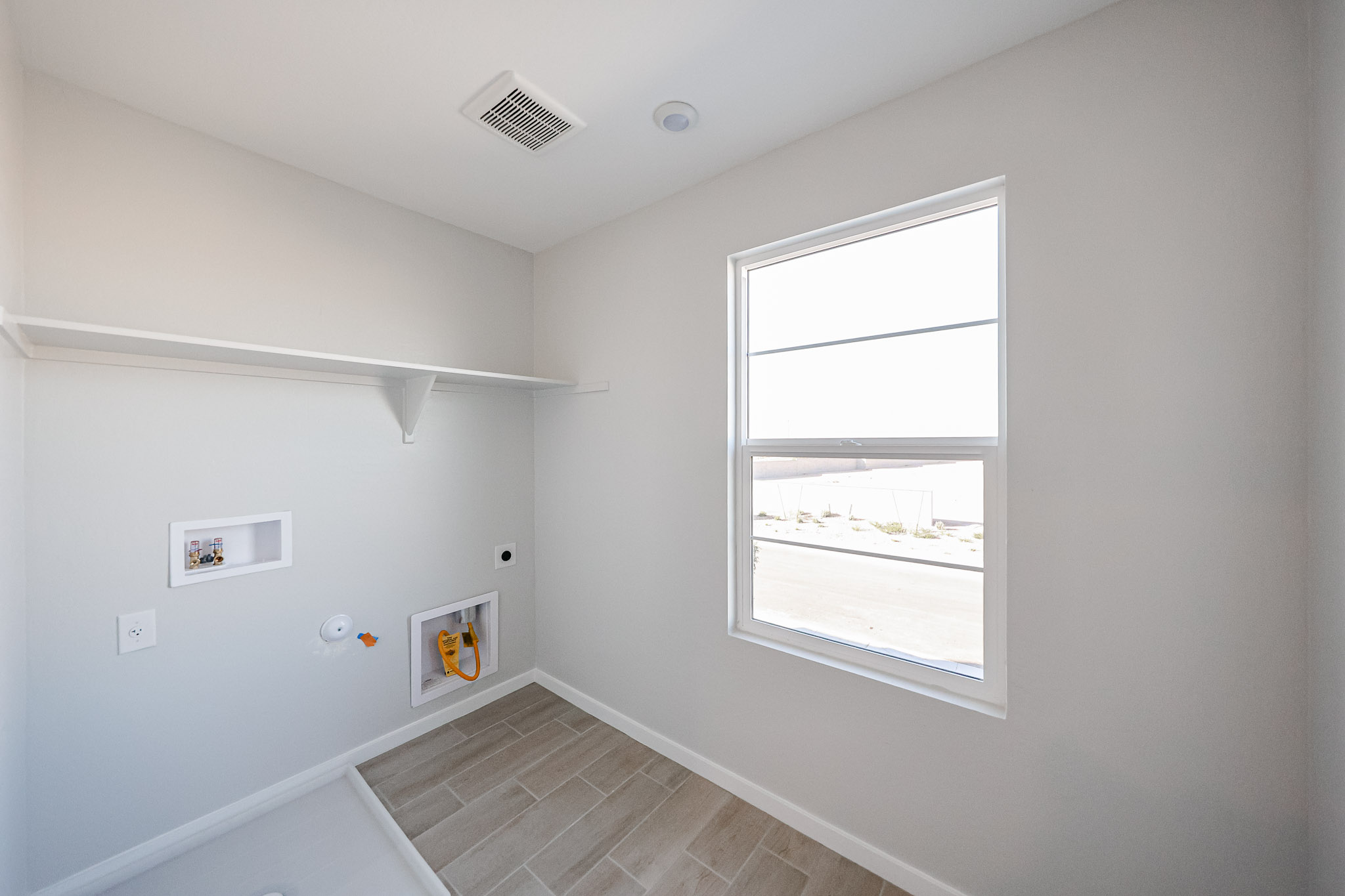A room with a window and a tile floor.
