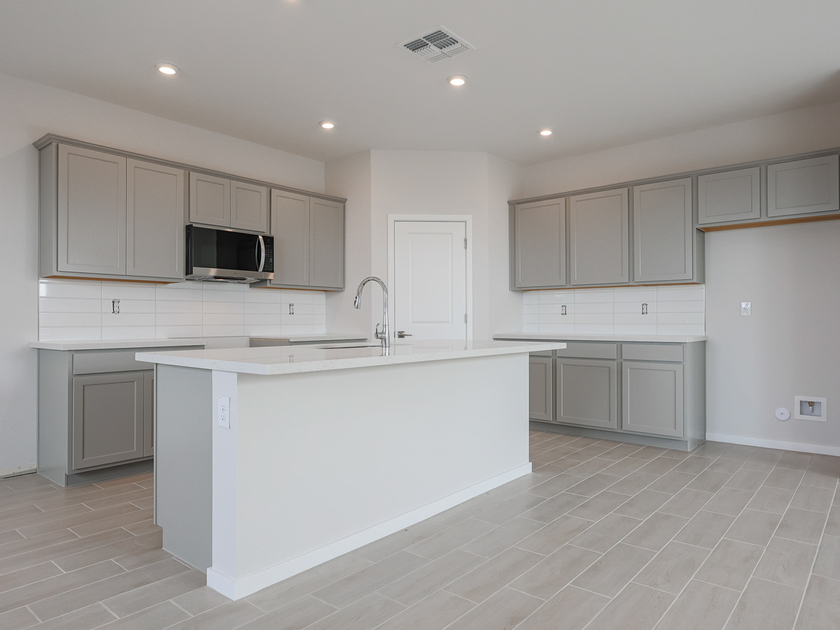 A kitchen with white cabinets.
