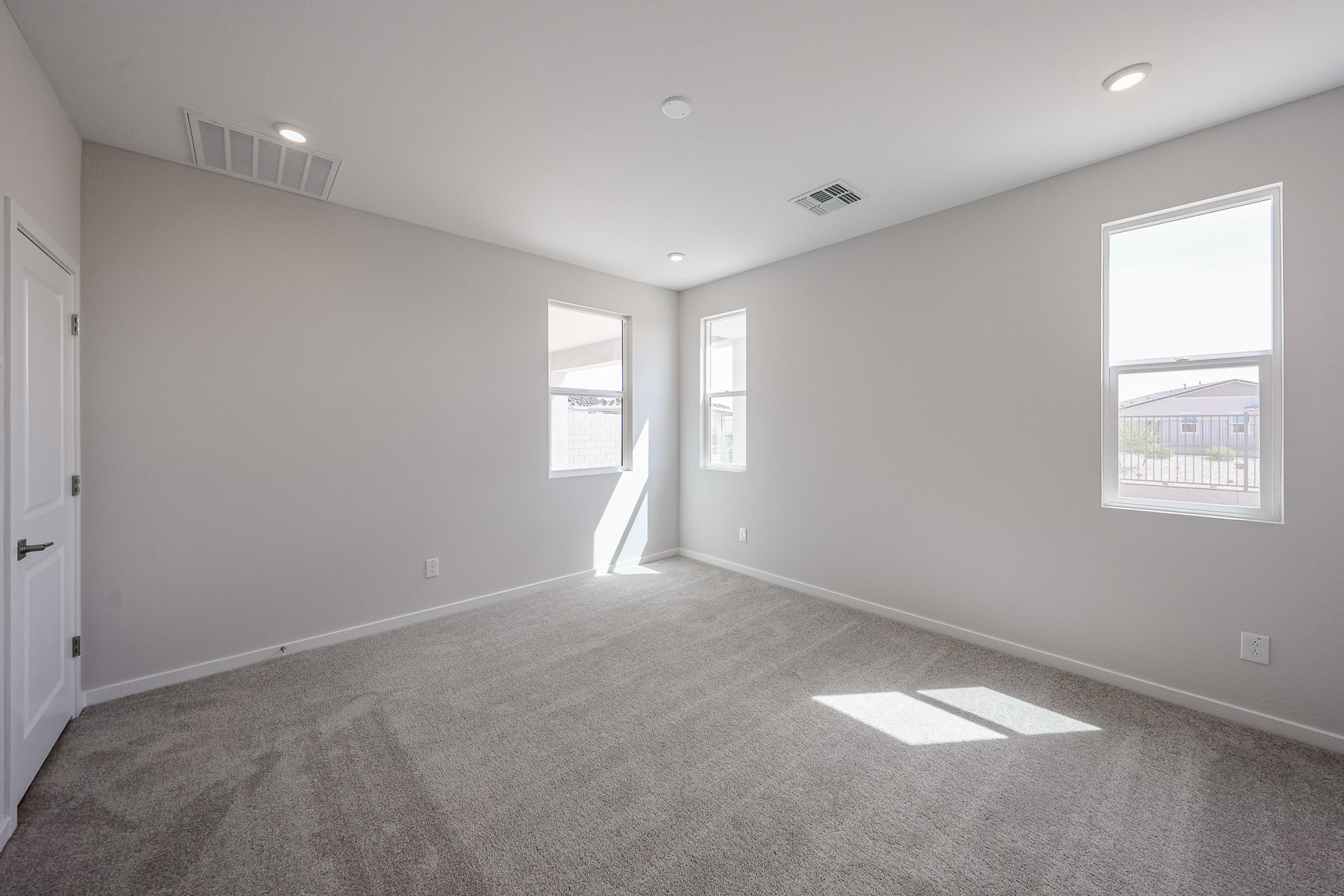 A room with a carpet and windows.