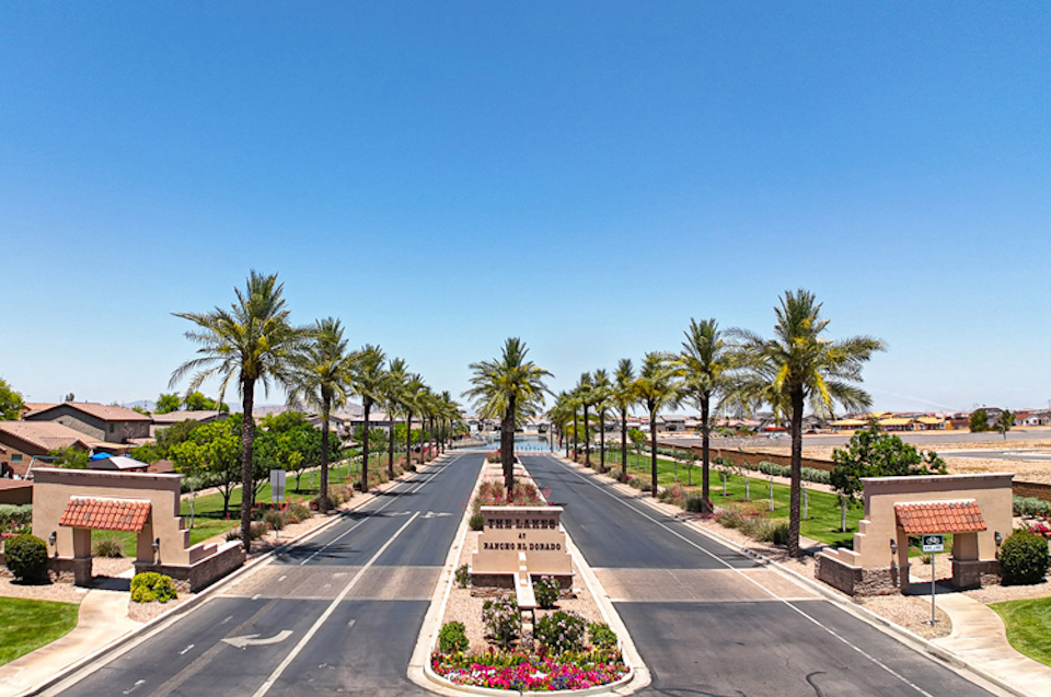 A road with palm trees and a sign on the side.