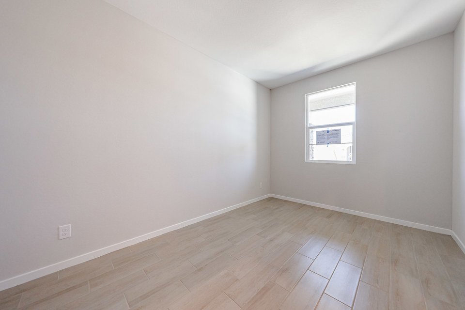 A room with a wood floor and a window.