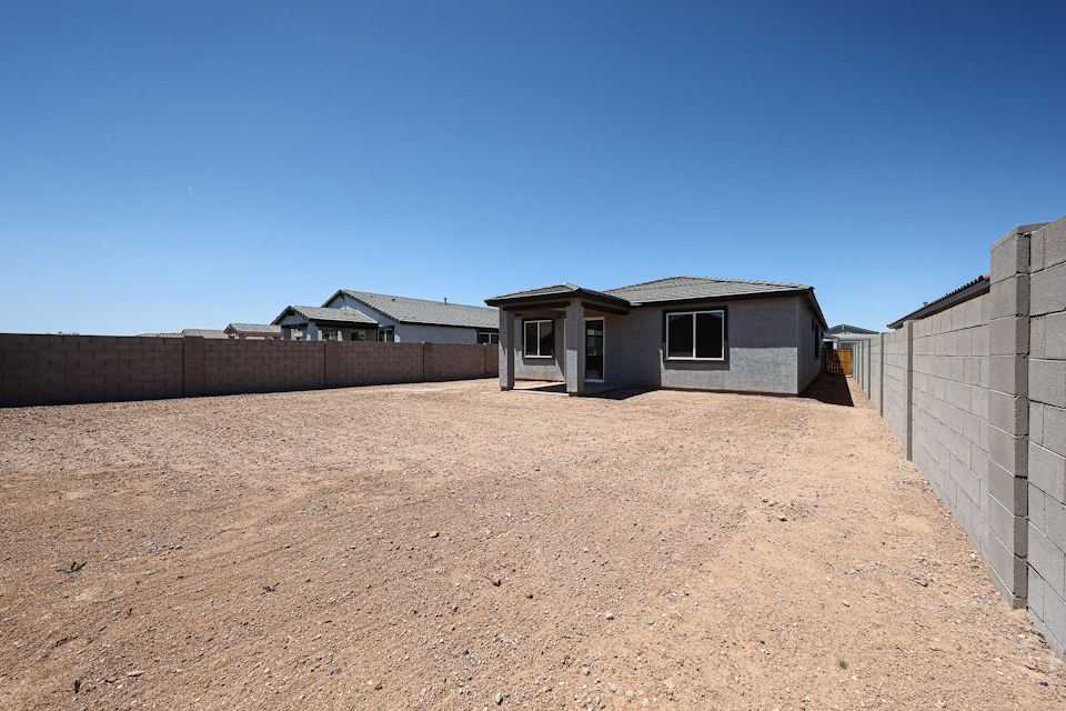 A dirt field with buildings in the background.