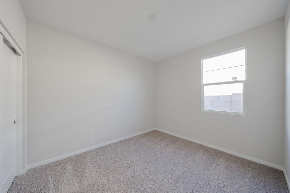 A room with a window and carpet.