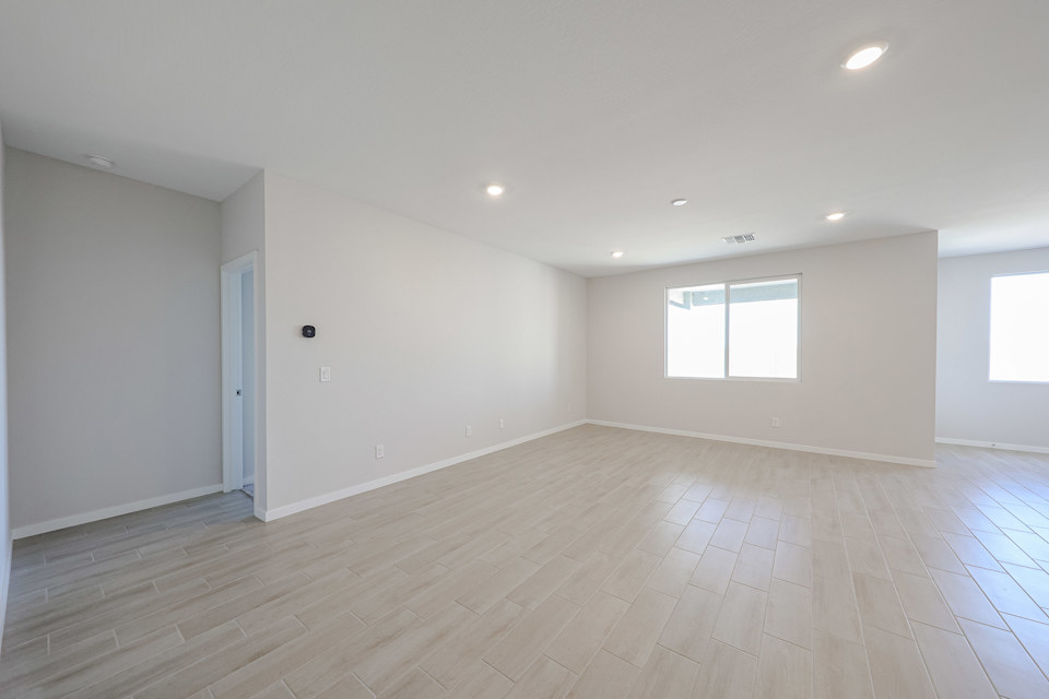 A room with a wood floor and windows.