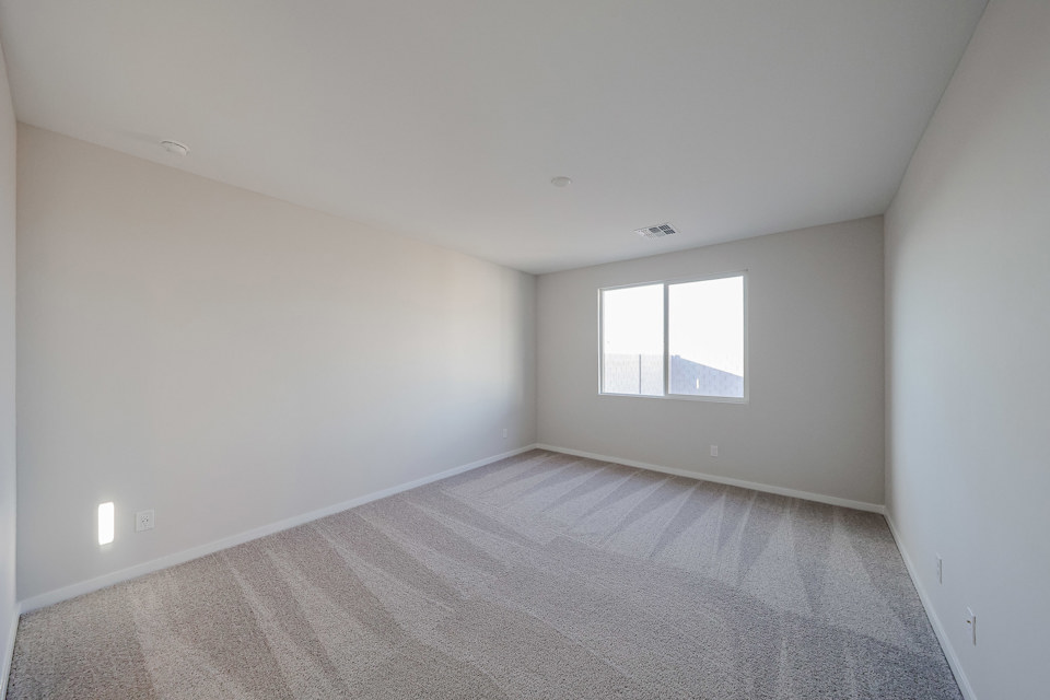 A room with a carpet and a window.