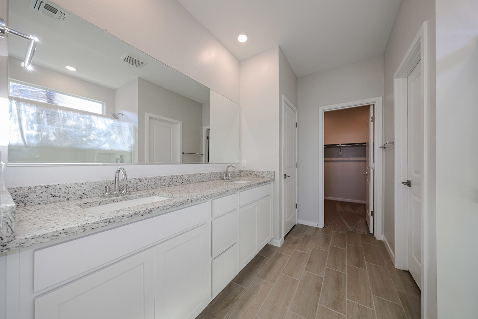 A bathroom with white cabinets.