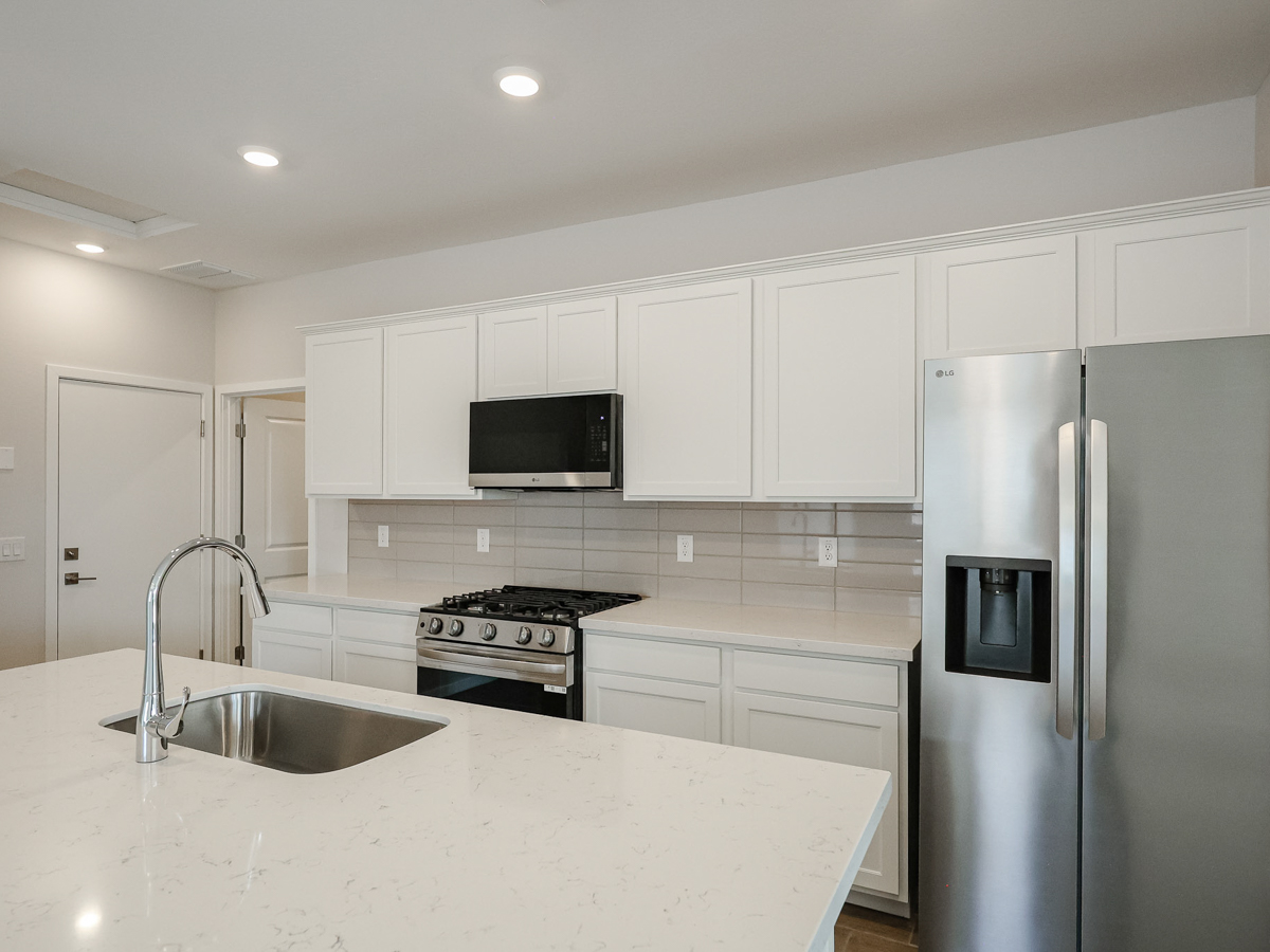 A kitchen with white cabinets.