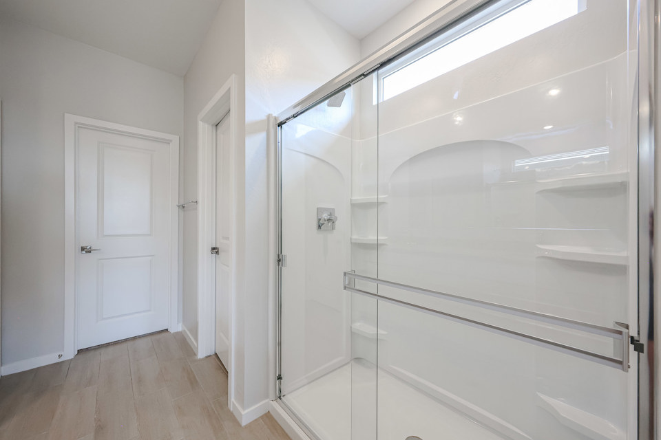 A white closet with glass doors.
