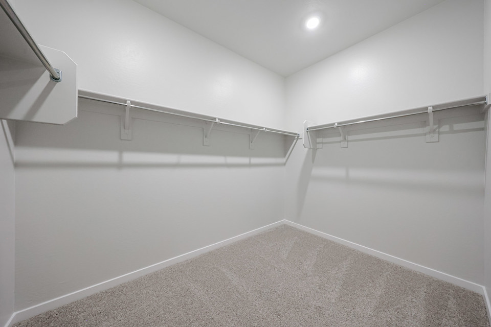 A white hallway with a metal railing.