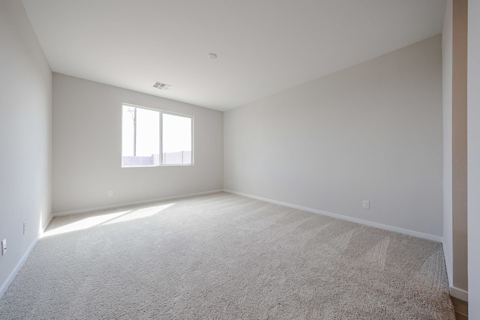 A room with a carpet and windows.