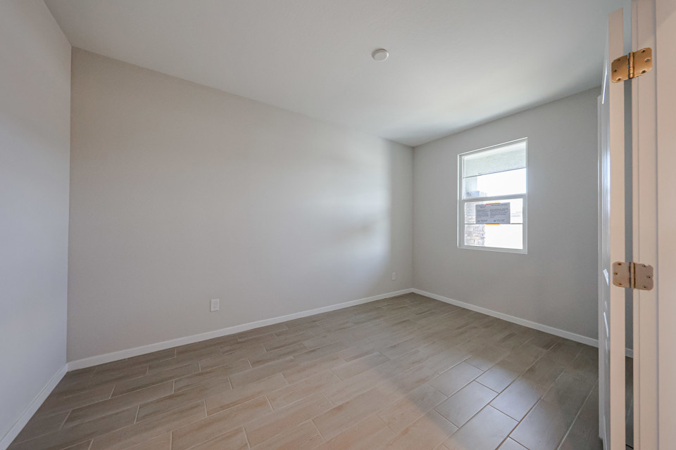 A room with a wood floor and a window.