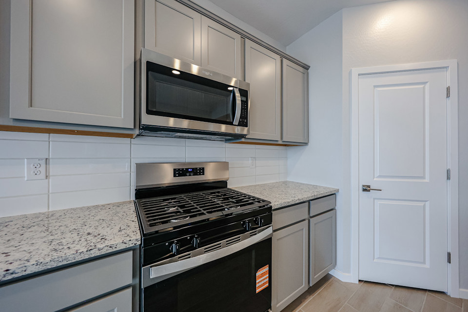 A kitchen with white cabinets.