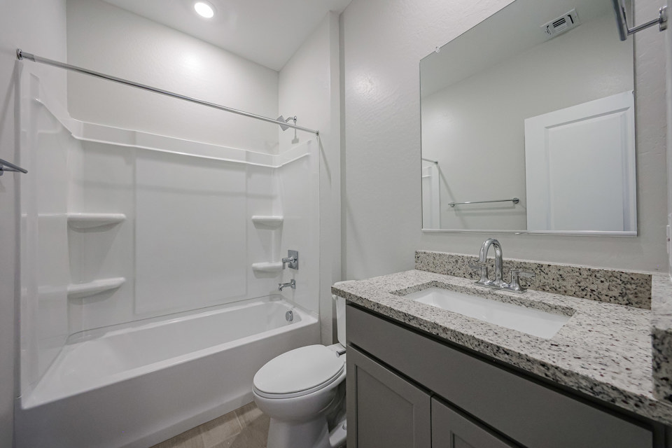 A bathroom with a marble countertop.