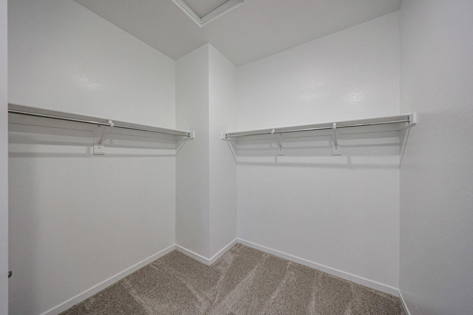 A white room with a shelf.