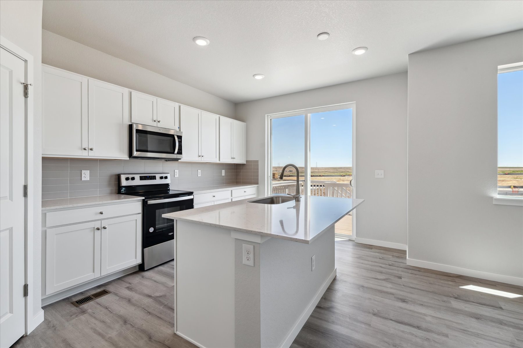 A kitchen with white cabinets.