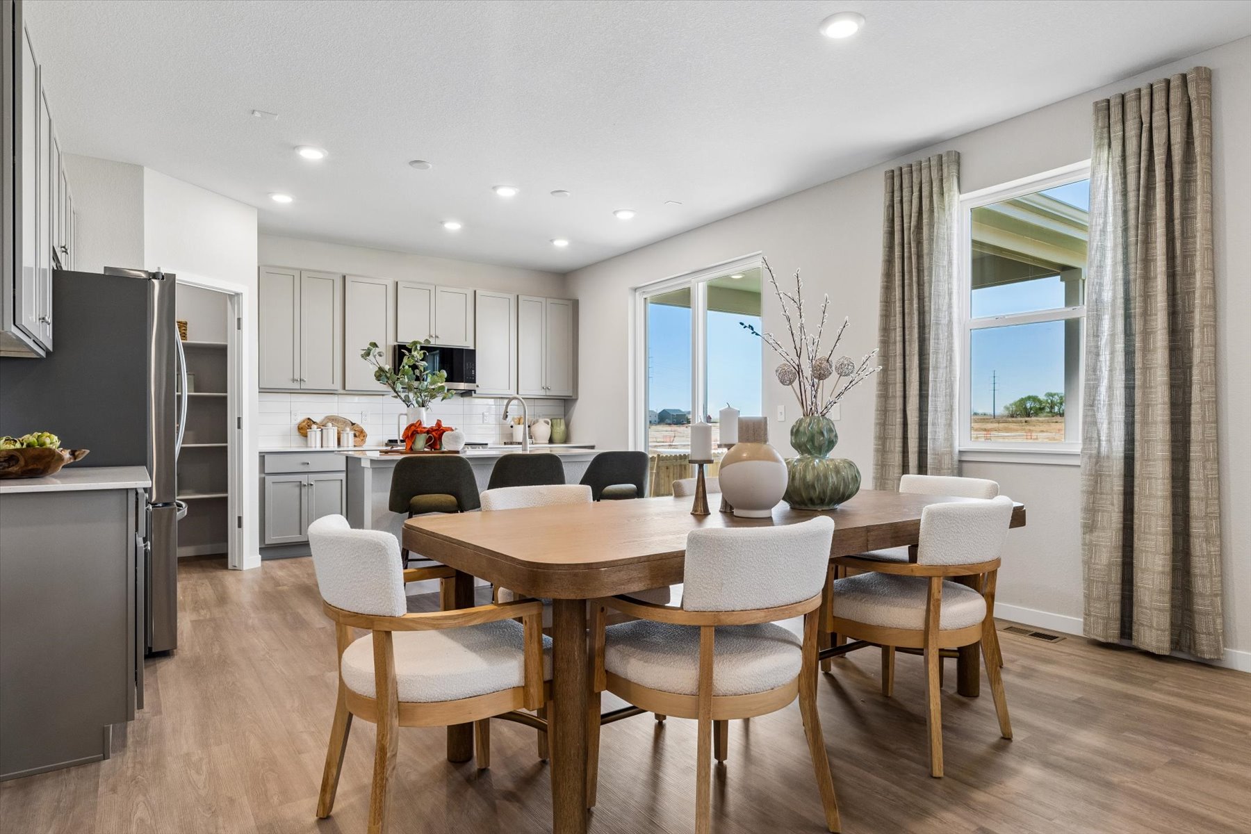 A kitchen with a dining table and chairs.