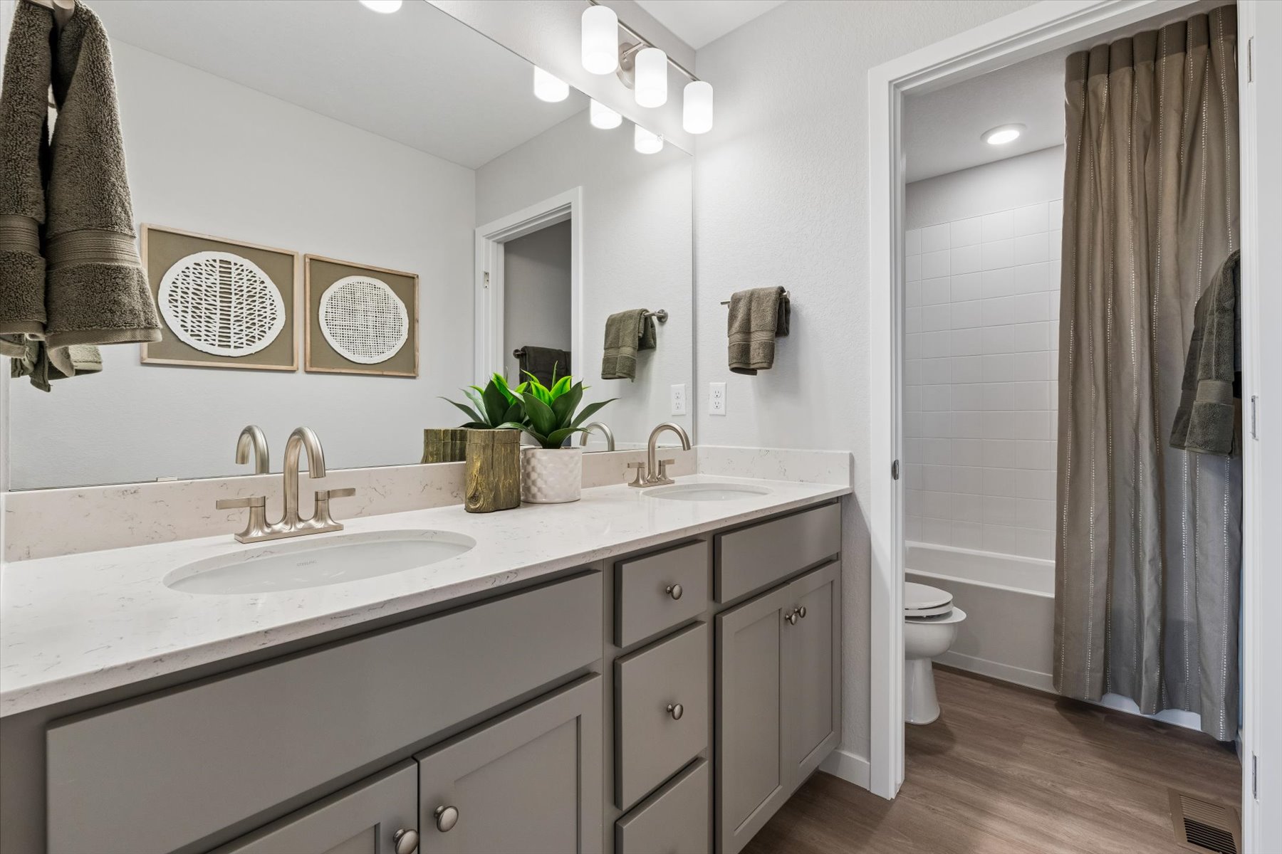 A bathroom with a sink toilet and mirror.