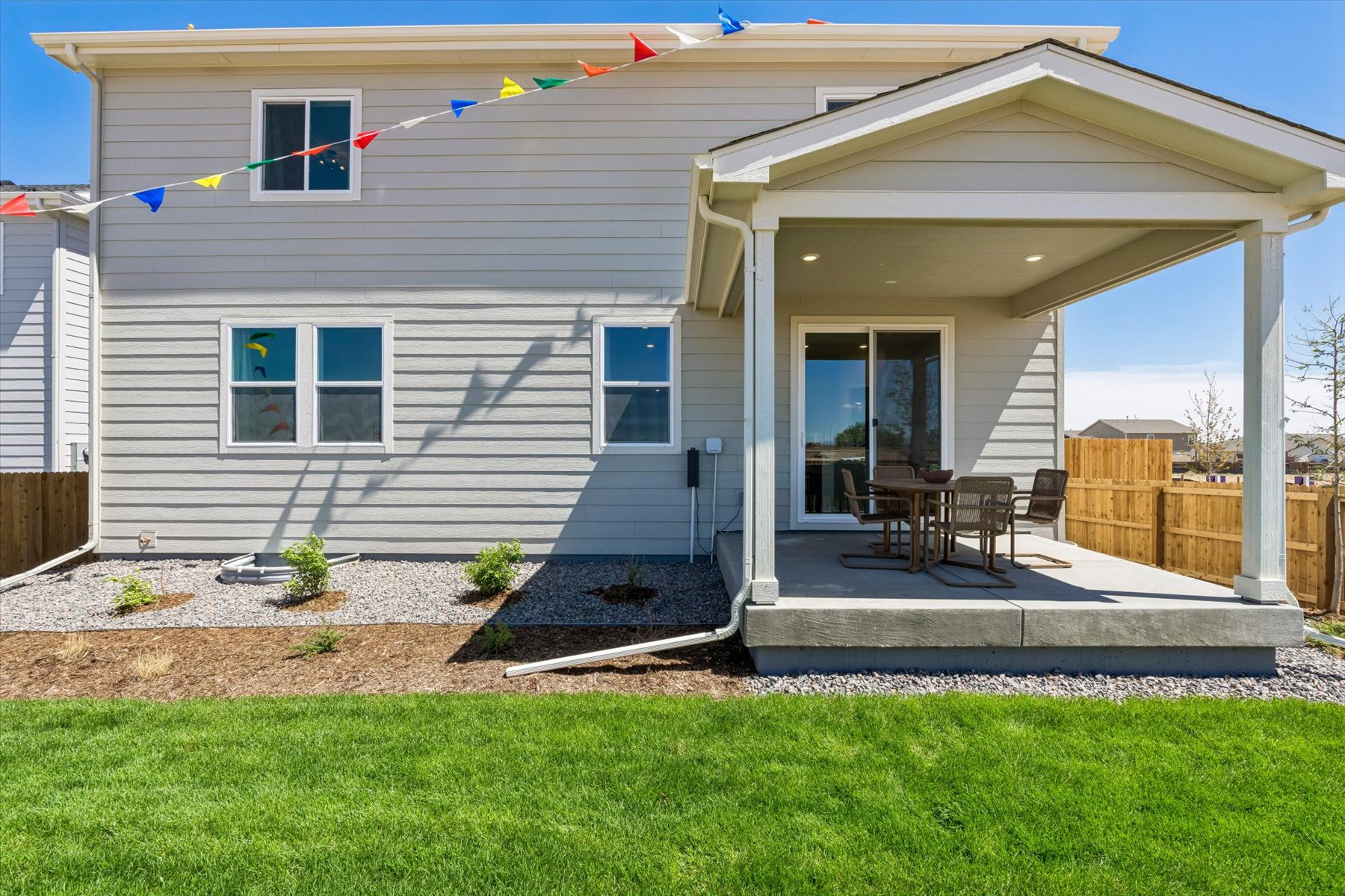 A house with a patio and a table and chairs in the front.