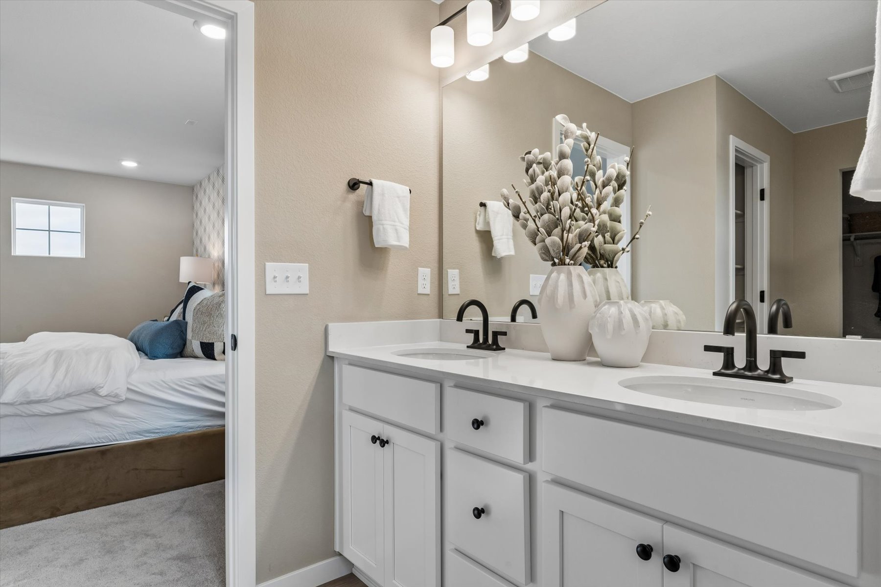 A bathroom with a sink and a bed.