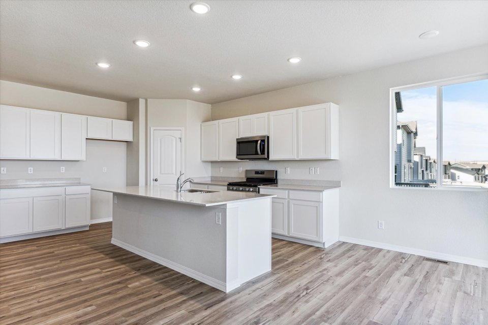A kitchen with white cabinets.