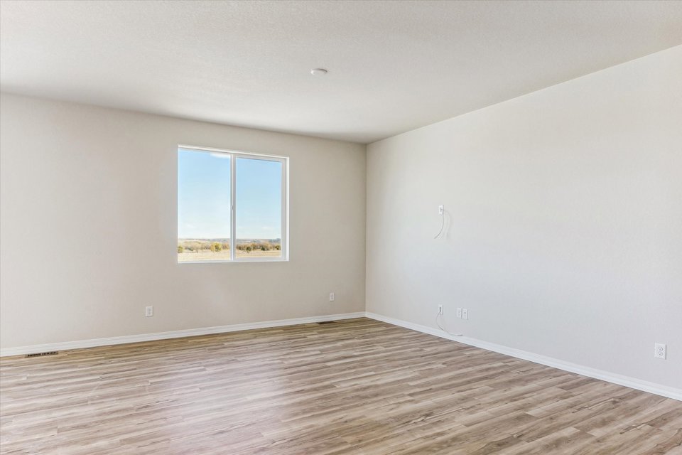 A room with a wood floor and a window.