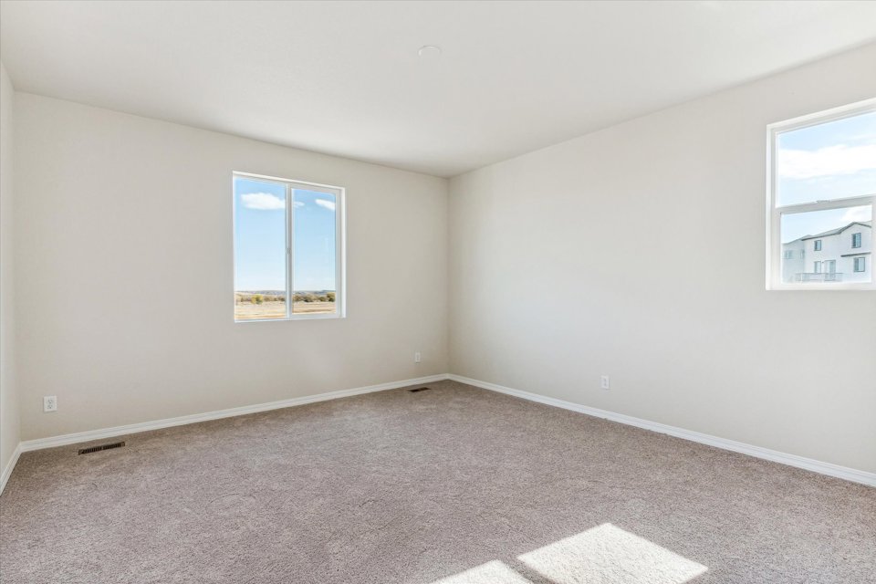A room with a carpet and windows.