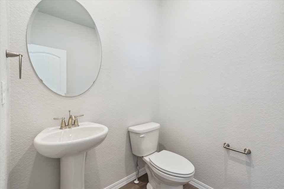 A bathroom with a round mirror.
